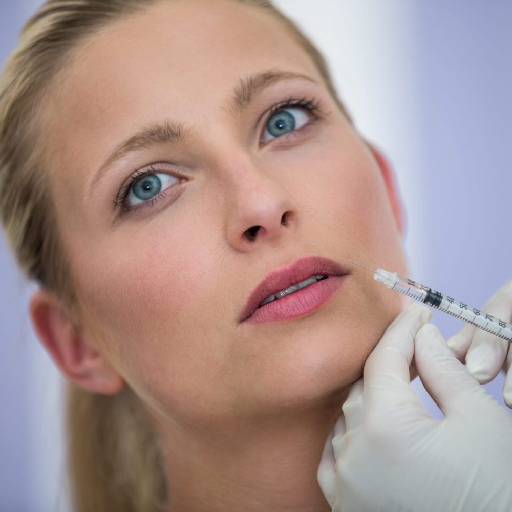 Close-up of female patient receiving a botox injection on face